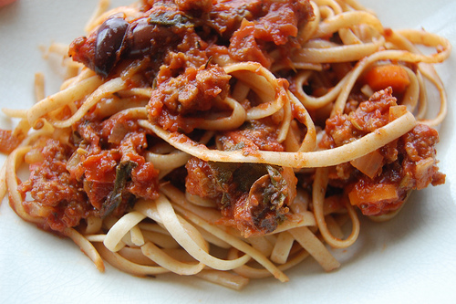 Spaghetti con salsa calabresa luciendo sus trozos de longaniza.