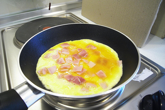 Puedes cortar el queso y el jamón en cubitos pequeños para envolver luego el omelette por la mitad.