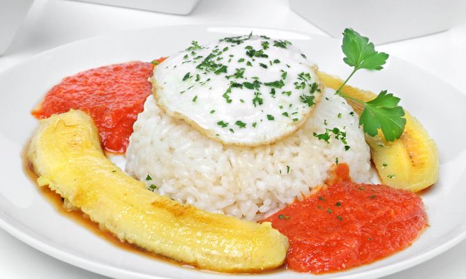 En una de sus variantes lleva salsa de tomates y cebolla rehogada para saborizar el arroz y unos dientitos de ajo picados finos.